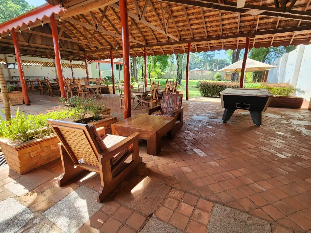 Shaded outdoor lounge with sofa seating under a thatched roof at Masindi Hotel