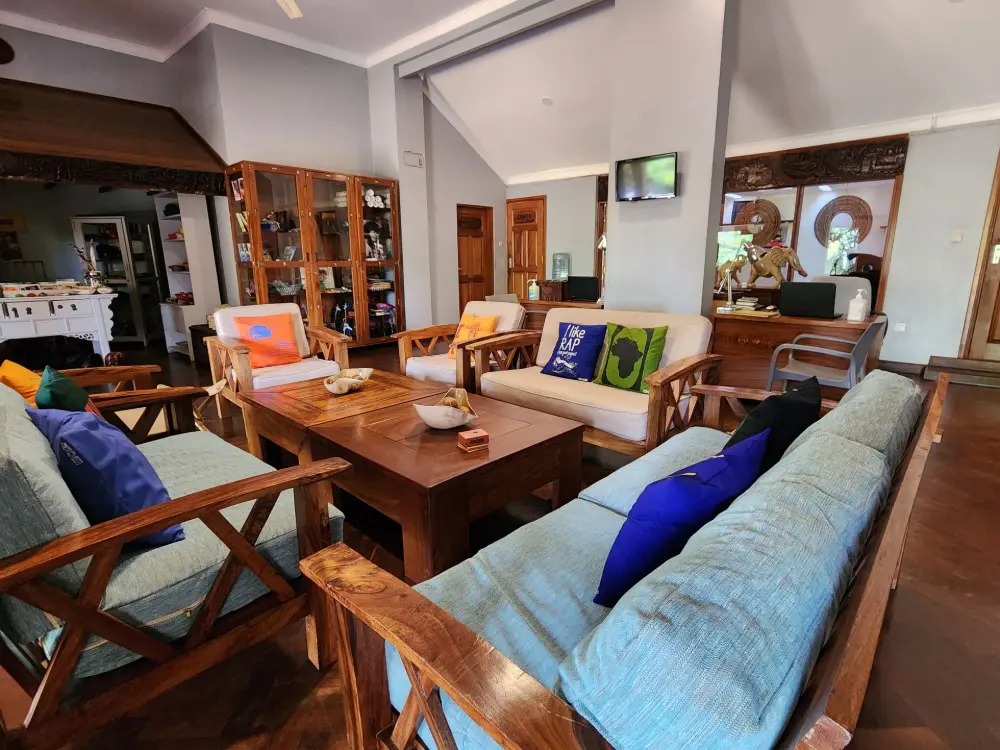 Indoor lounge area with sofas, cushions and a wooden coffee table at Masindi Hotel
