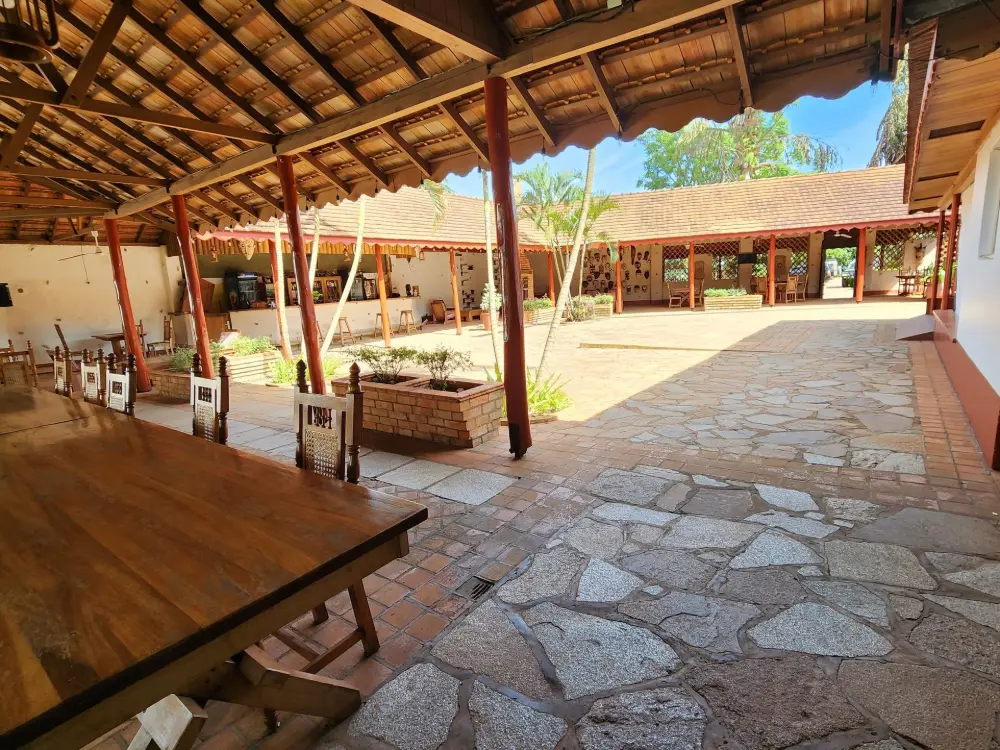 Terrace walkway under a thatched roof overlooking the courtyard at Masindi Hotel