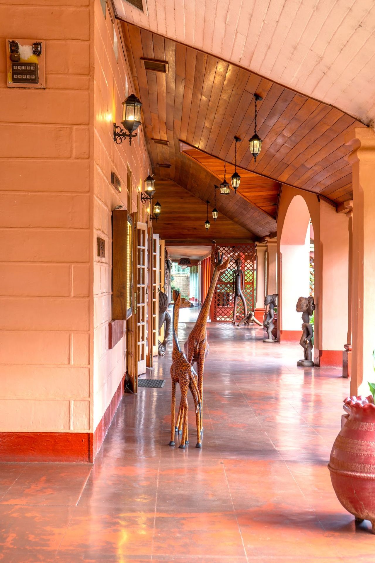 The covered walk at Masindi Hotel, hung with carvings