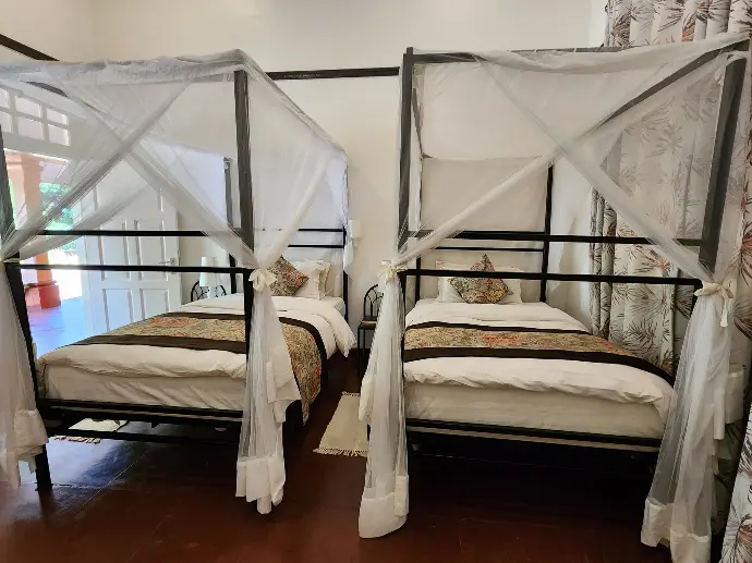 The Baker Deluxe twin room at Masindi Hotel, two beds under mosquito nets