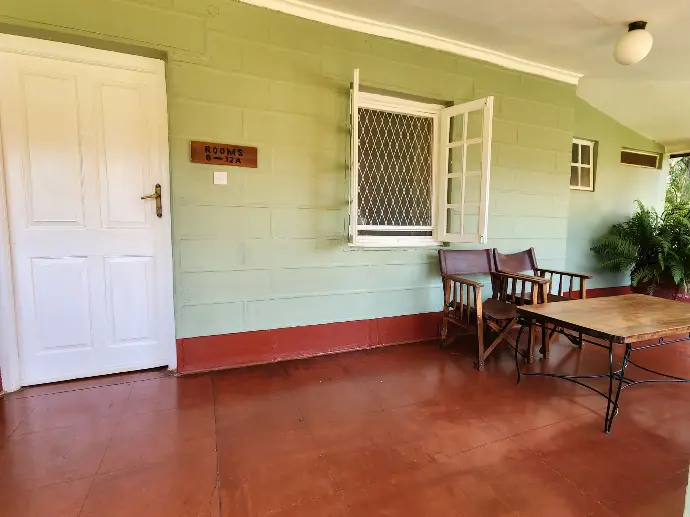 Private veranda with table and chairs outside a guest room at Masindi Hotel
