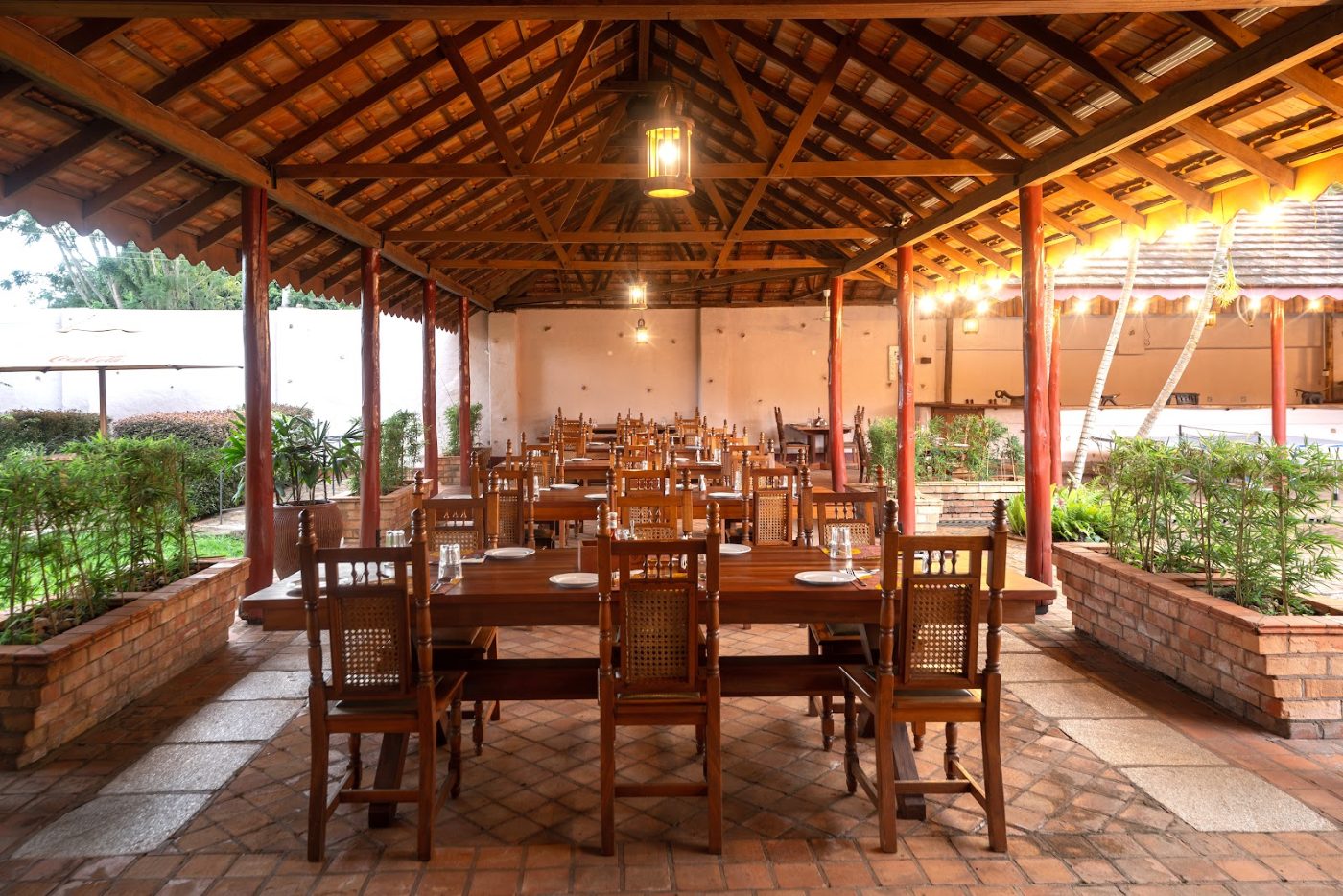 Tables laid under the thatch in the courtyard at Masindi Hotel